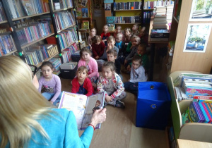 Dzieci słuchają bajki czytanej przez panią Małgorzatę Hofamnn.
